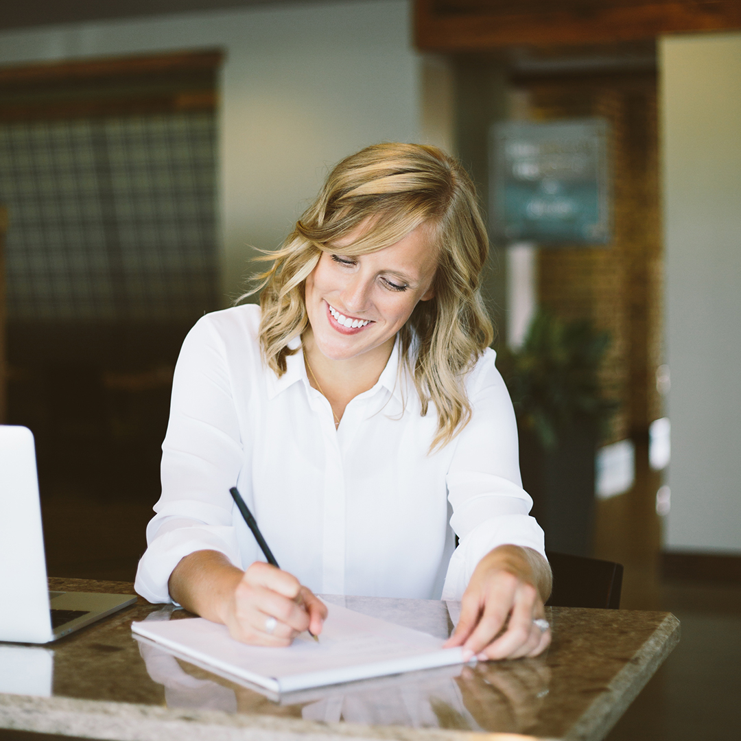 Laurel sits at her desk